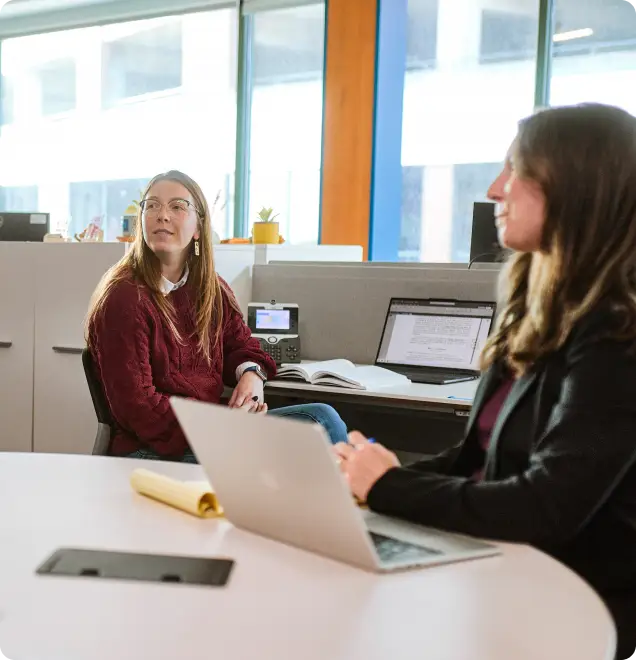 two female faculty members chatting in office
